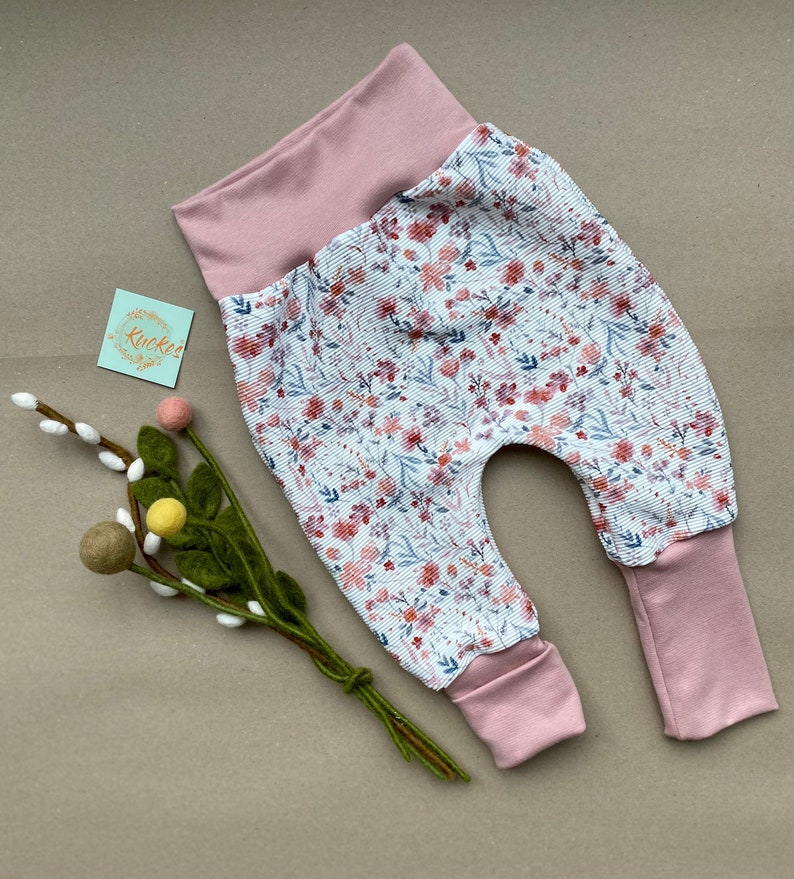 Pumphose für Kleinkinder mit Stoff aus Ribjersey mit weißem Stoff und Wildblumen und Rosa Bündchen.