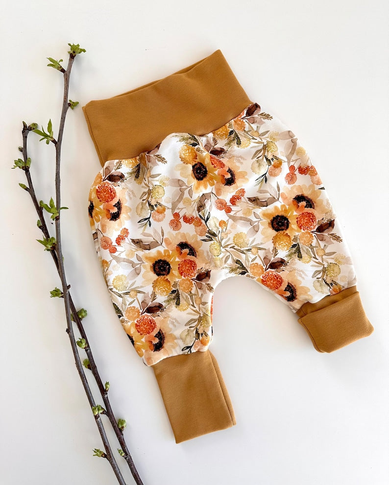 Pumphose für Kleinkinder mit Stoff aus Ribjersey mit Sonnenblumenmuster und hellbraunen Bündchen.